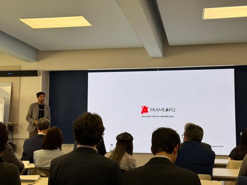 Daniel Barba Gázquez presentando FrameARQ ante una sala llena, con el logotipo de la empresa proyectado en pantalla